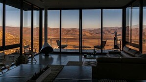 Amplia sala de estar con grandes ventanales que ofrecen vistas al paisaje desértico.
