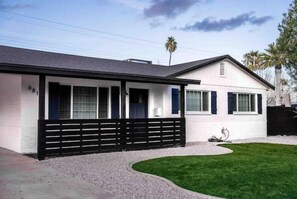 A modern two-story house with a covered porch and a well-maintained lawn. - Diamond Desert Gem: Heated Pool & Spa Oasis, 5 min from Old Town Scottsdale! (Scottsdale)