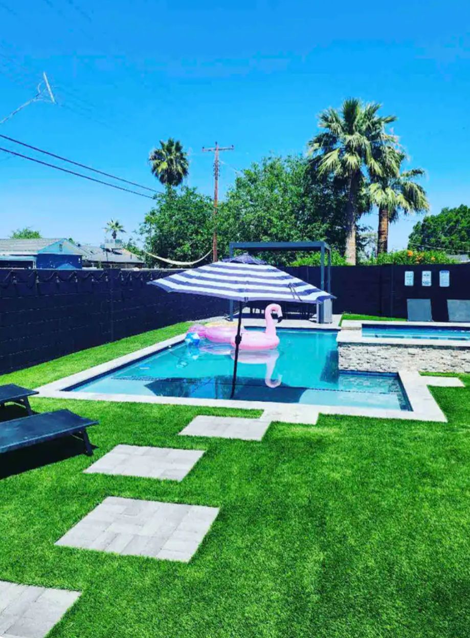 Ein Garten mit Swimmingpool, Hängematte und einem Flamingo-Schwimmpfad.