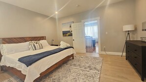 Una camera da letto con un letto, un comodino, una cassettiera e una lampada.