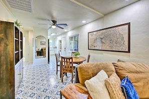 Relax in this open-plan living area with a dining space, featuring a sofa, dining table, and wall-mounted map.