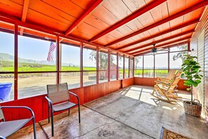 Relax in this serene outdoor space with a view of the surrounding green field and distant hills.