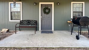 A front porch with a bench, a door with a wreath, a grill, and two windows. - Cozy country retreat!- Close to River Run and Lake Jacksonville (Jacksonville)