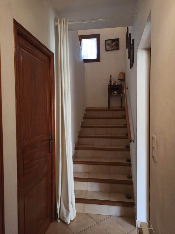 Un escalier avec des marches en bois et une porte blanche sur le côté gauche.