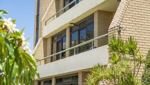 Un edificio de varios pisos con fachada de ladrillo, ventanas grandes y un balcón.