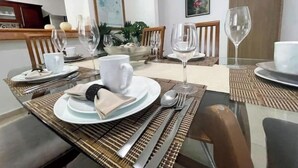 A dining area with a table set for four, including plates, cutlery, and glasses. - Casa Mar y Amor / pool and interior garden18 PXS (Cancún)