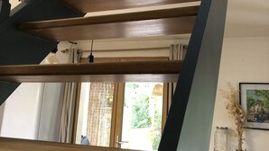 Un escalier en bois, doté de balustres sombres et d’une main courante, menant à l’étage supérieur.
