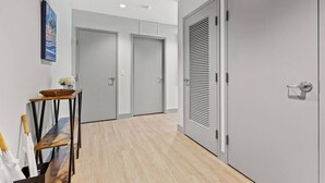 A hallway with grey doors, a wooden table with a bowl, and a framed picture on the wall. - 175 LEX - Two Bedroom Condo, Walkable Downtown! (Lexington)