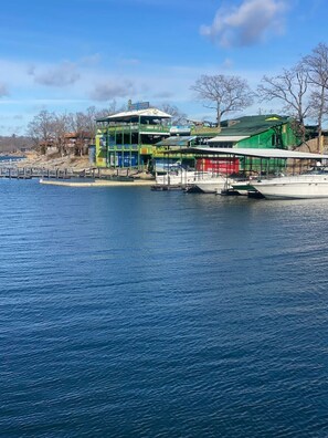 Ein mehrstöckiges Gebäude direkt am Wasser mit angestaubten Booten und freiem Blick auf das Wasser.