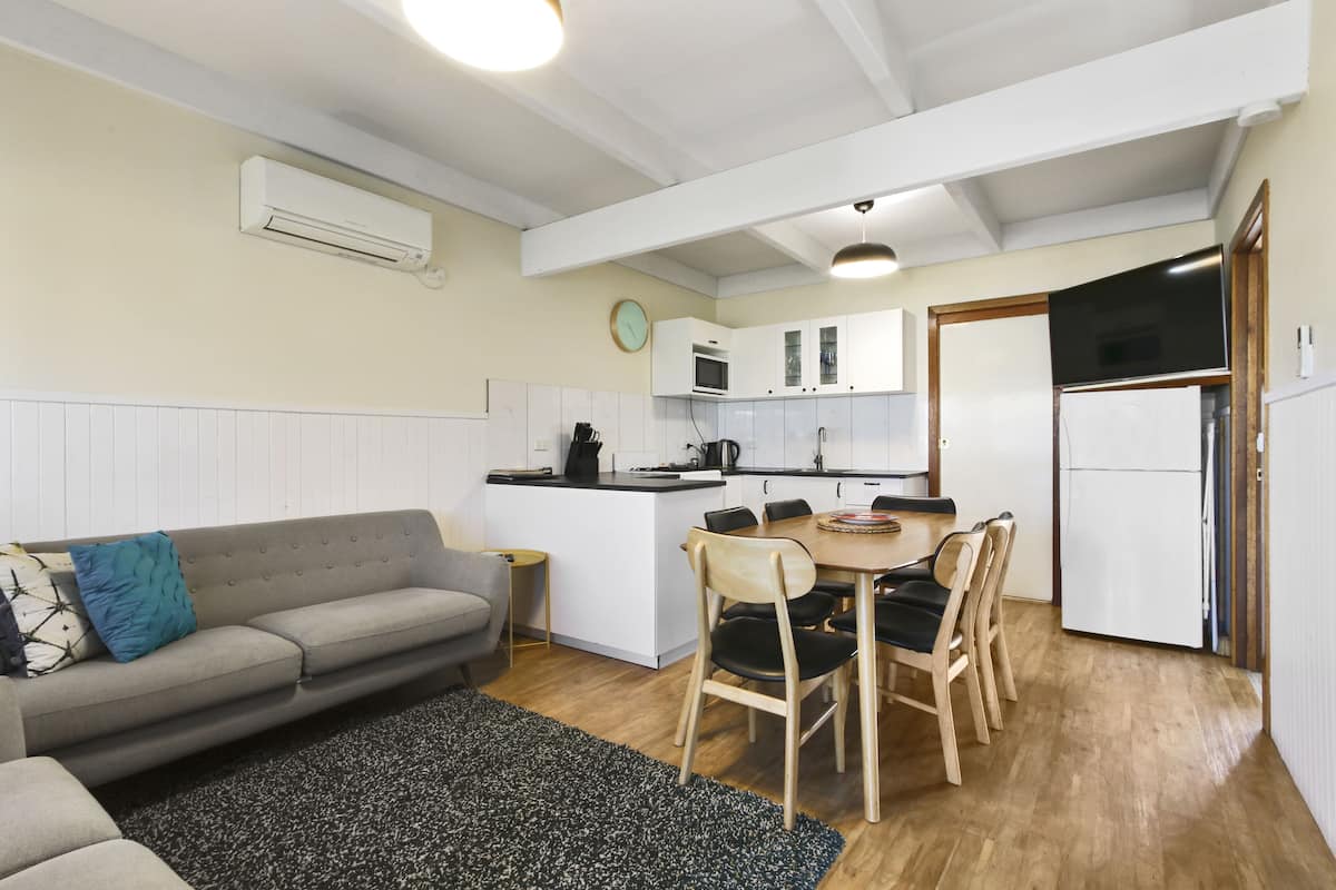 A compact living space with a kitchenette, a dining area, and a sofa.