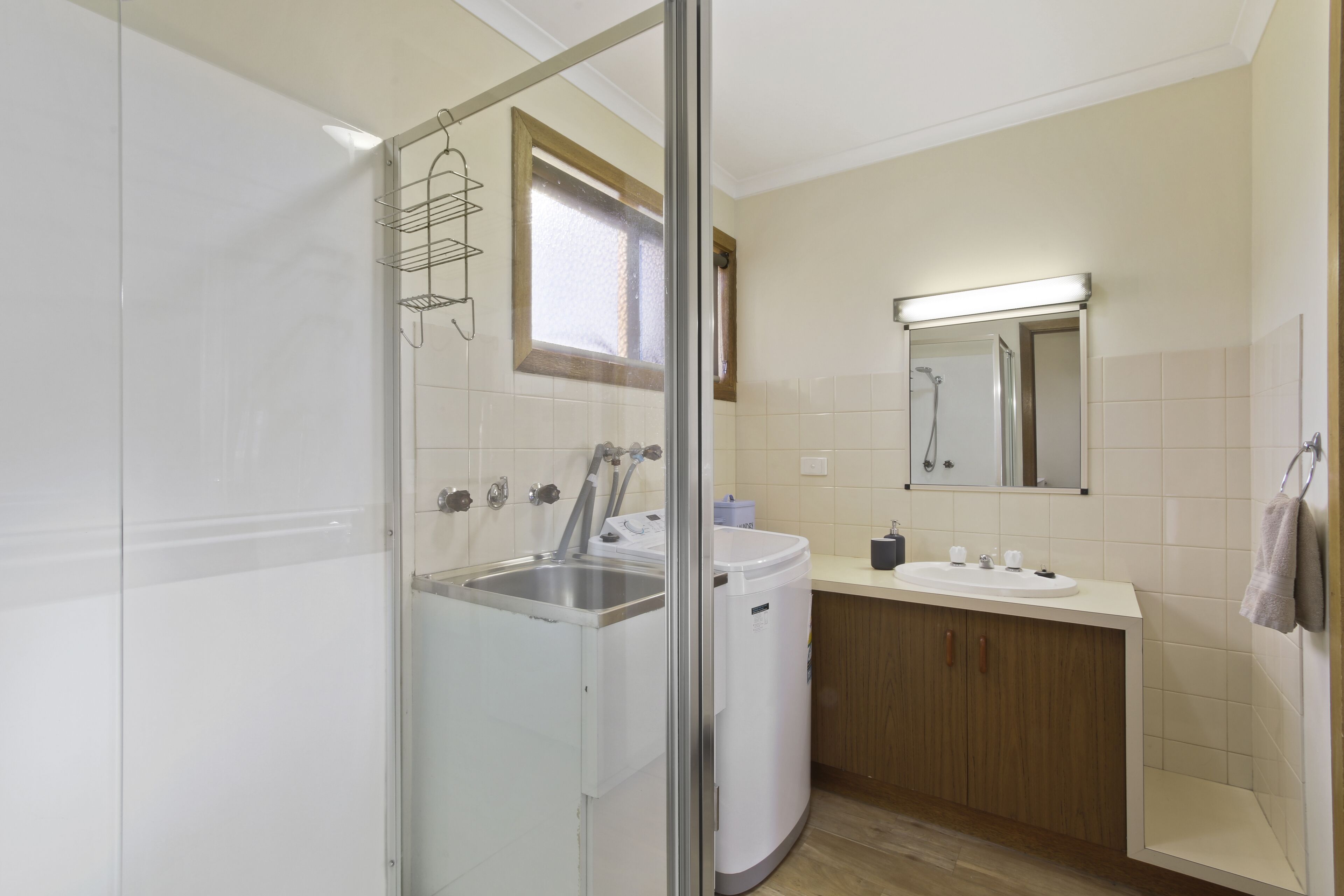 A modern bathroom with a glass-enclosed shower, a built-in sink, and a mirror above the vanity.
