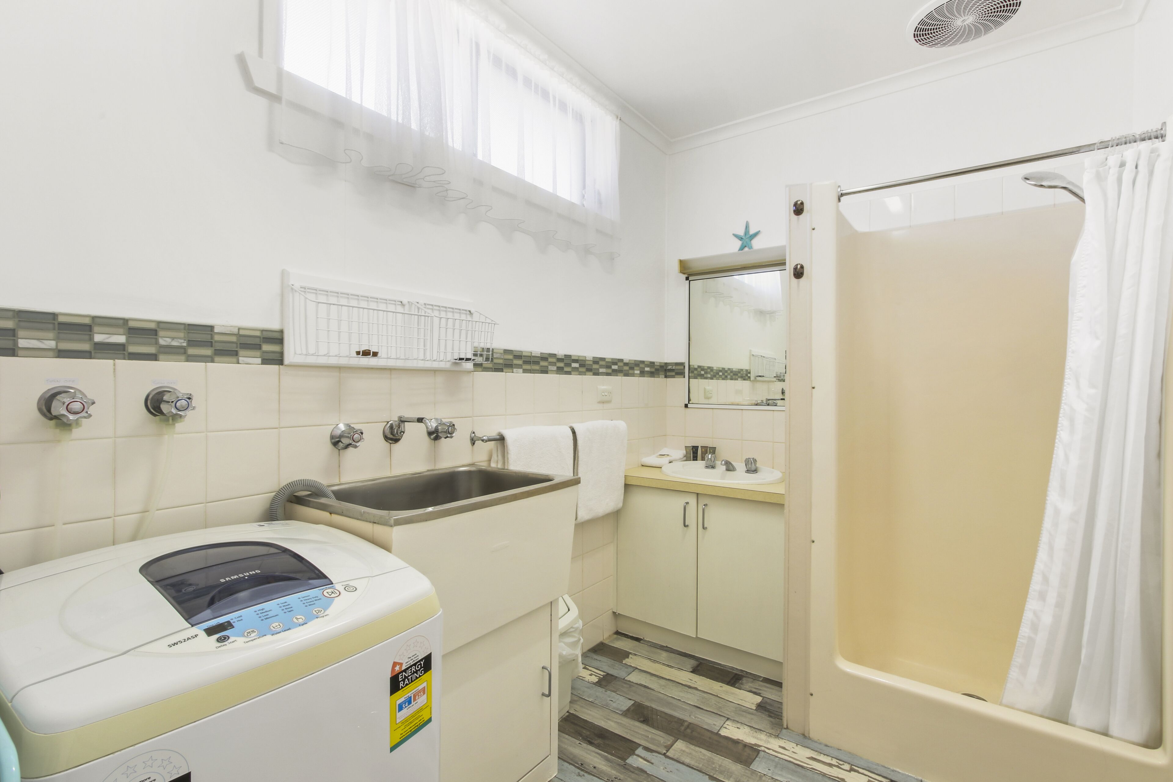 Een kleine badkamer met een wastafel, toilet en douche.