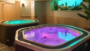 Two hot tubs with built-in lighting, a wooden wall, and a large aquarium above them. - Beautiful apartment in Saint-Affrique with WiFi (Saint-Affrique)