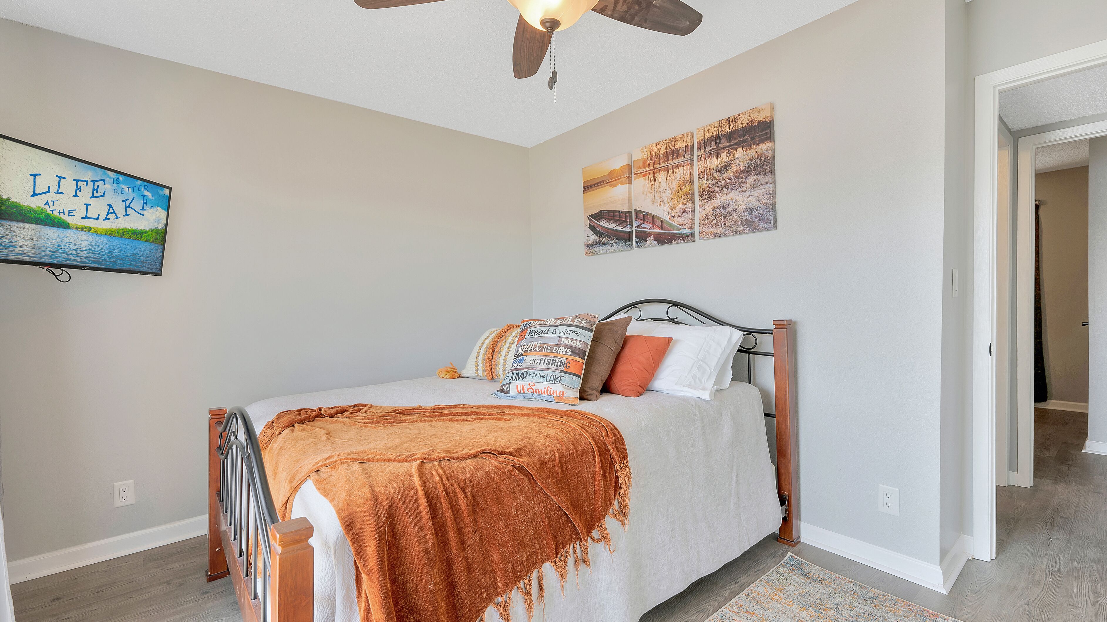 Un dormitorio con cama, ventilador de techo y decoración en las paredes.