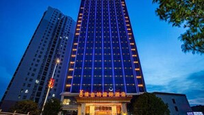 Un alto edificio di un hotel con una facciata moderna e finestre illuminate.