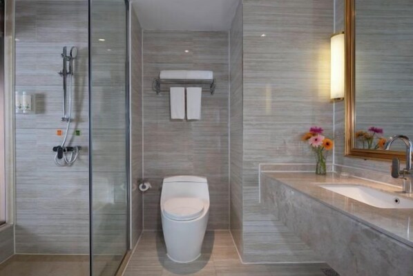 A modern bathroom with a glass shower enclosure, a toilet, and a sink with a mirror. - Vienna International Hotel (Bijie Dafang Branch) (Bijie)