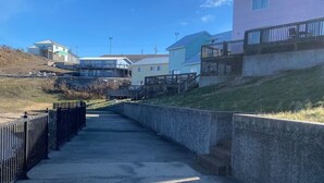 A concrete pathway leading to a residential area with houses on both sides. - Studio D Sleep 6- Bachelor/Bachelorette Parties! (Lake Ozark)