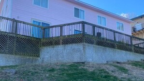 A pink building with a wooden fence and a grassy slope. - Studio D Sleep 6- Bachelor/Bachelorette Parties! (Lake Ozark)
