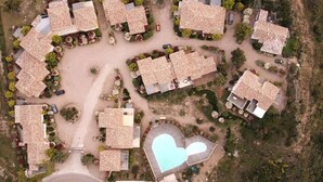 Eine Vogelperspektive eines Wohngebiets mit mehreren Häusern, einem Pool und einer gewundenen Straße.