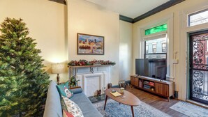 A cozy living room with a fireplace, a television, a Christmas tree, and a sofa. - Cincinnati Retreat w/ Patio & Grill! (Cincinnati)