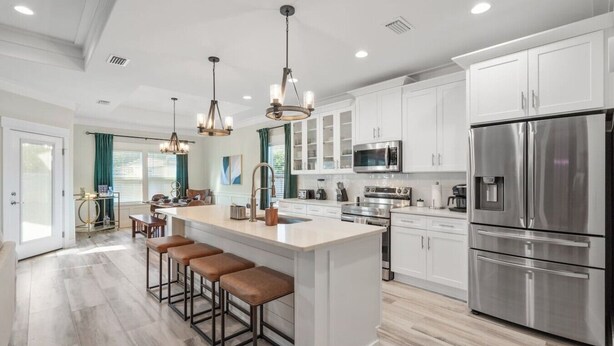 A modern kitchen with a central island, stainless steel appliances, and pendant lighting. - • Emerald-Gem-Inn • PCB • Family Fun Beach Home! • (Panama City Beach)
