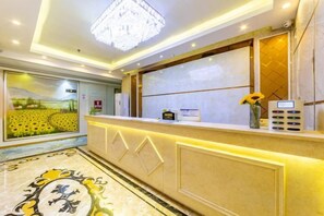 A hotel reception area with a reception desk, a chandelier, a large window with a view, and a decorative floor pattern. - Jinkuihua Hotel (Shenzhen Futian Port) (Shenzhen)