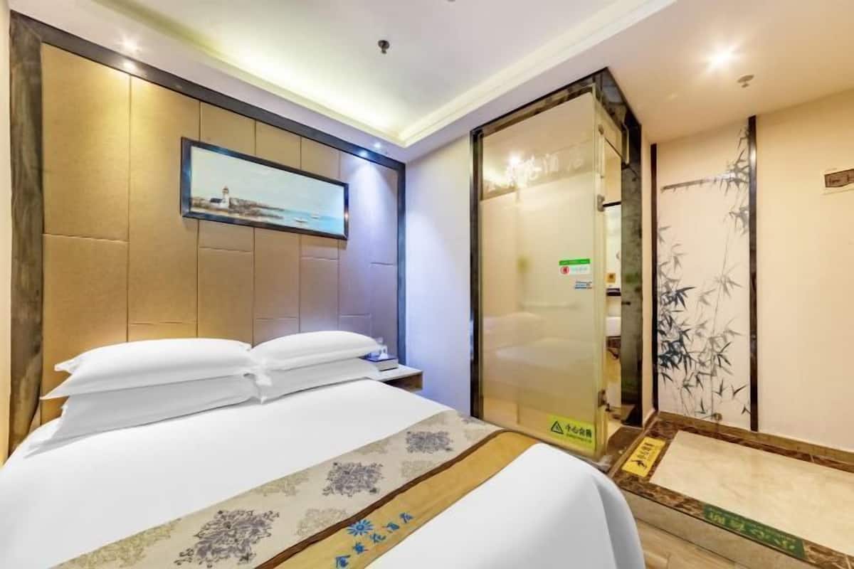 Une chambre d’hôtel avec un lit, un tableau accroché au mur, une porte coulissante et un mur décoratif en bambou.