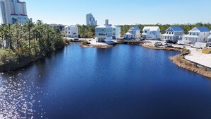 A waterfront property with multiple houses, a river, and a forested area. - 3BR Home @ Summer Salt • Sleeps 9 • Resort Pool & Near Beach (Orange Beach)