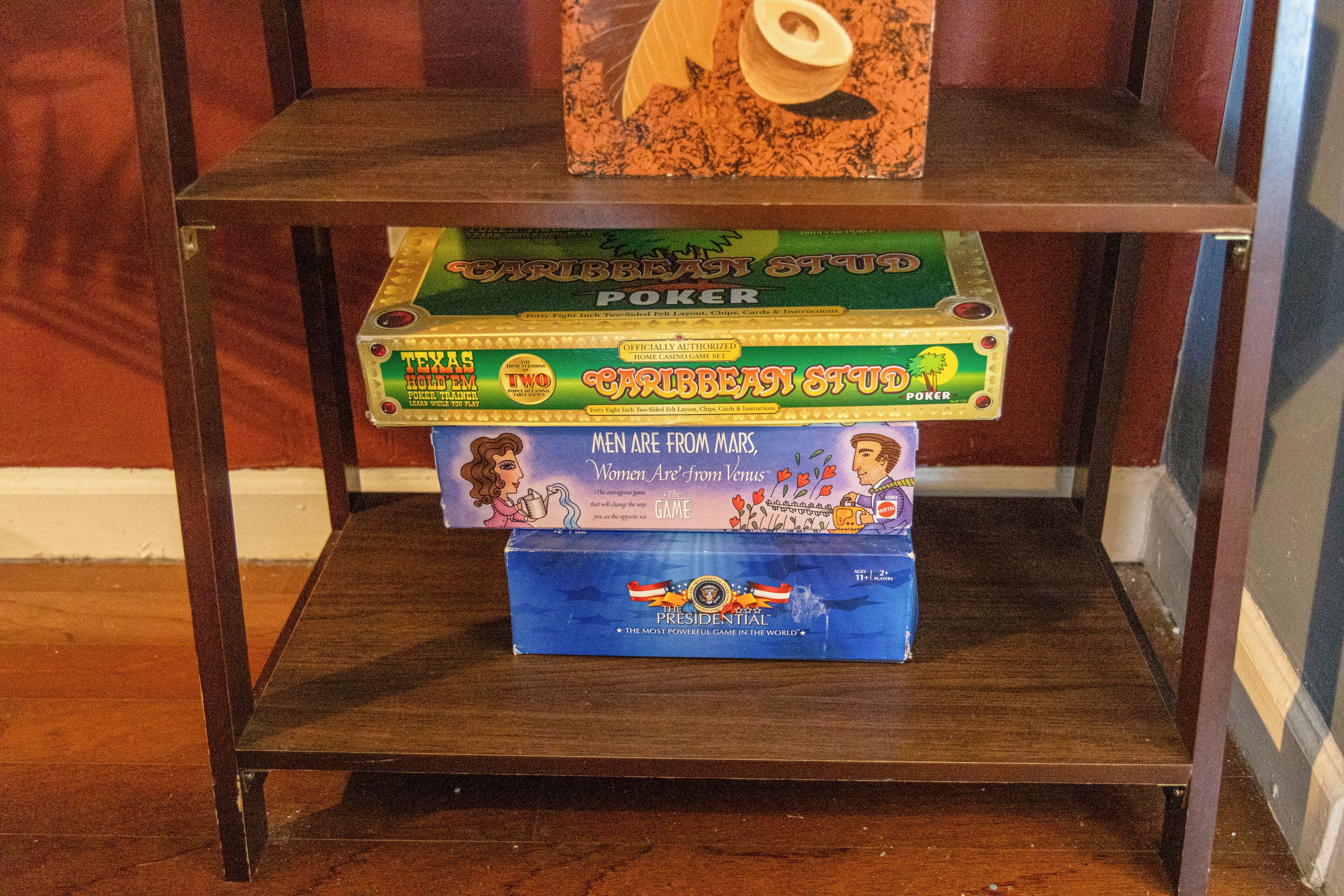 A shelf with three board games: 'Caribbean Stud Poker,' 'Texas Hold'em Poker,' and 'The Presidential.'