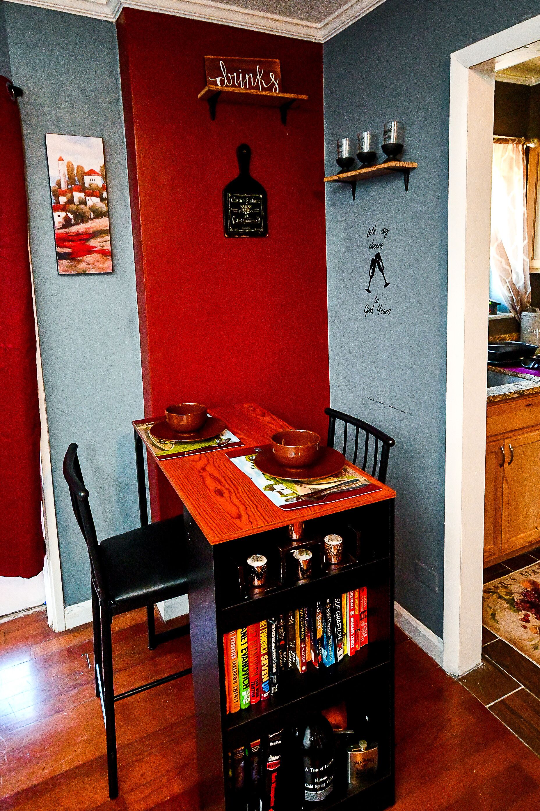 Un coin repas avec une table en bois, des chaises et une bibliothèque remplie de livres.