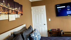 A hotel room with a bed, a TV mounted on the wall, and a door. - Modern High-Floor condo at Heart of Downtown & Skyline Balcony (Atlanta)
