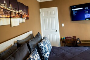 A hotel room with a bed, a TV mounted on the wall, and a door. - FIFA 1BR Dtwn ATL-Skyline Balcony | 1mi to Stadium (Atlanta)