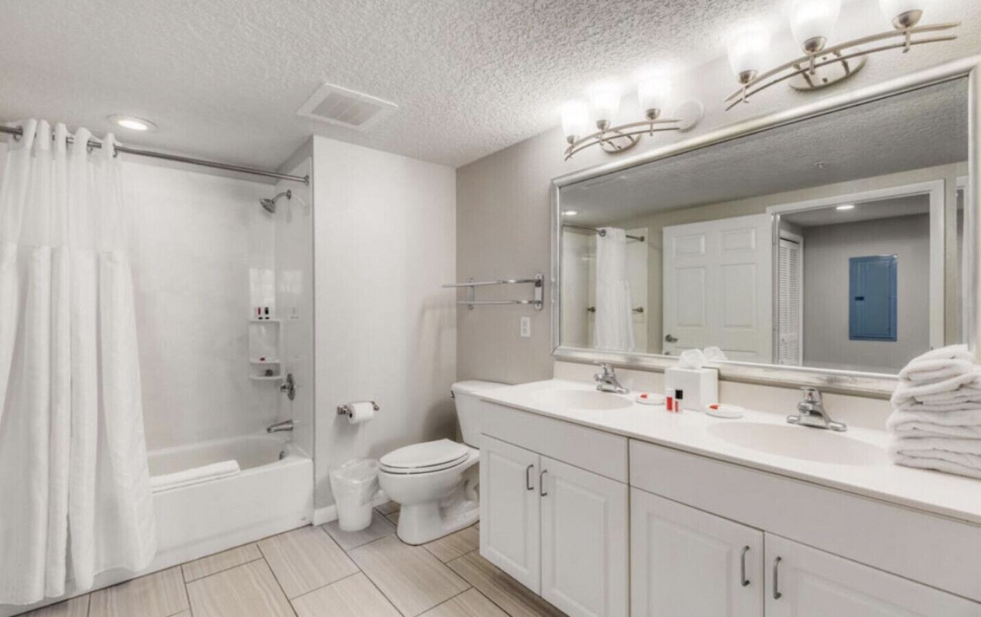 A modern bathroom with a shower, toilet, and sink.