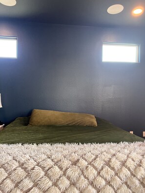 Cozy bedroom with a plush bed and soft rug.