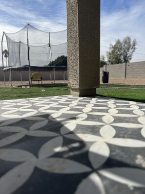 Stroll through a serene courtyard with a patterned floor and a striking concrete pillar.