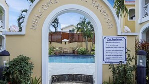 A pool area with a sign stating "Welcome to the Harbour" and "Pool Regulations" including details like pool hours and usage rules. - 2 Bedroom townhouse ideally located in Rodney Bay - Harbour #7 (Rodney Bay)
