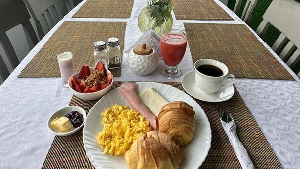A breakfast table with food, a view of the sea, and a sign reading "LIBERTAD 109". - HOTEL LIBERTAD 109  (La Libertad)