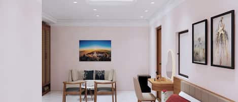 A modern hotel room with a large bed, a desk with a mirror, a chair, a sofa, and a painting on the wall.