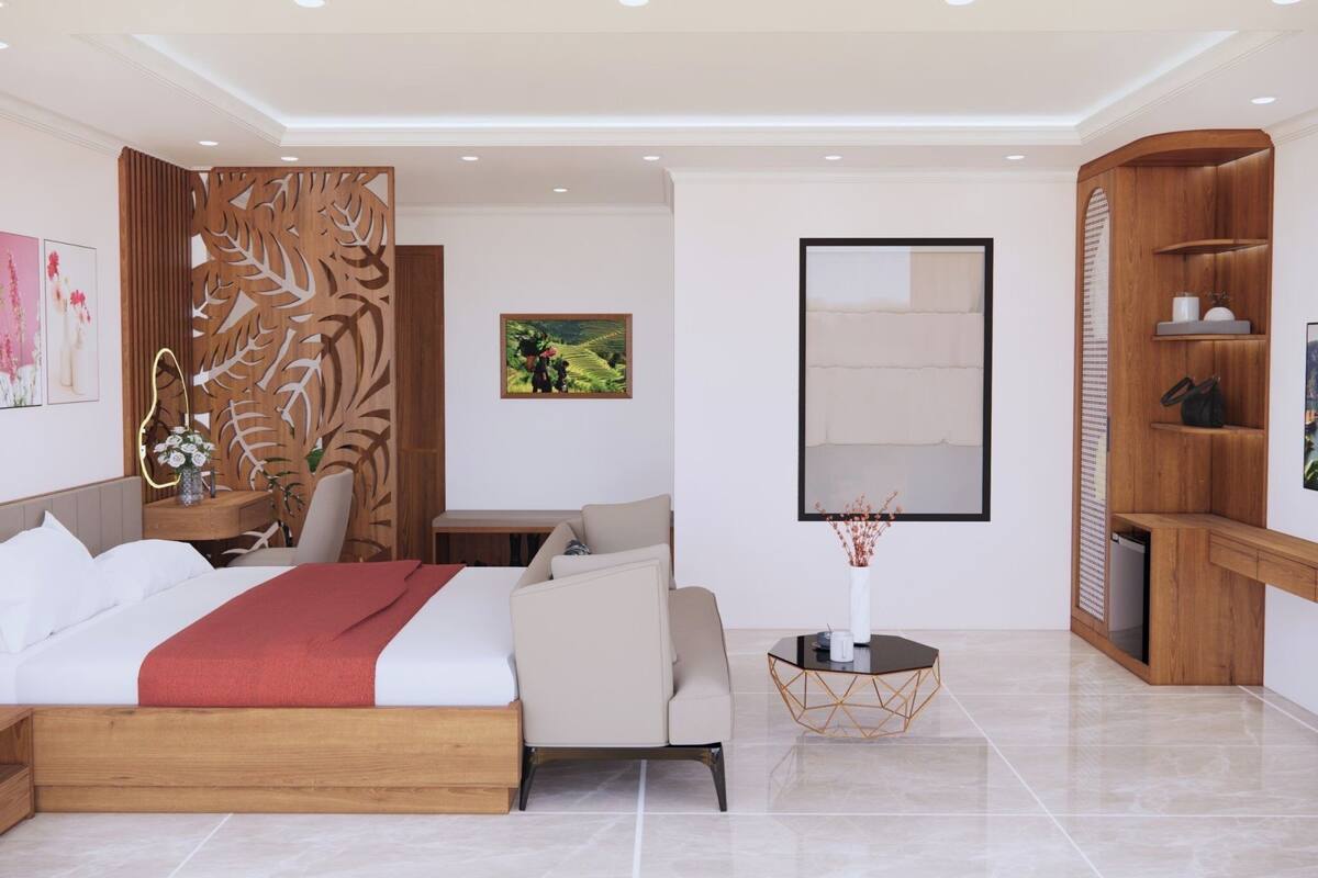 A modern hotel room with a bed, a desk, a chair, a small table with a vase, and a wooden cabinet.