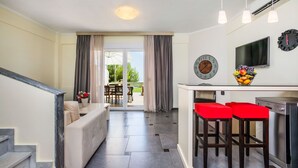 Une cuisine moderne avec un coin repas, un canapé et un escalier.