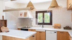 A modern kitchen with wooden cabinets, a white countertop, and a built-in dishwasher. - CostaBlancaDreams - Casa Leo in Benissa Costa (Benissa)