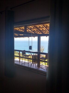A room with a view of the sea through a window with a wooden balcony. - Farol House (Marica)
