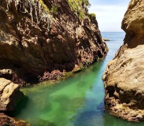 A coastal landscape with rocky cliffs and a clear water channel. - Farol House (Marica)