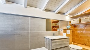 A modern bathroom with a bathtub, a sink, and a toilet. - La Suite Darray - Welkeys (Megève)
