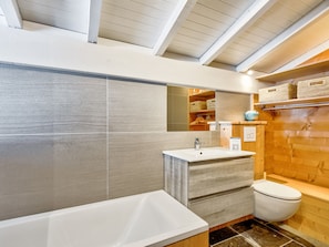 Un baño moderno con bañera, lavabo e inodoro.