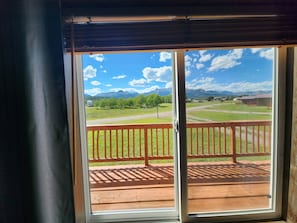 A view from a room with a sliding glass door leading to an outdoor deck with a wooden railing.