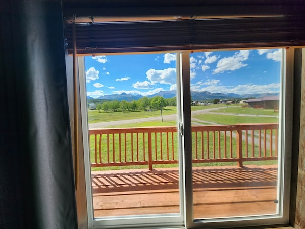 A view from a room with a sliding glass door leading to an outdoor deck with a wooden railing.