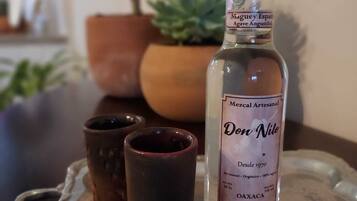 Eine Flasche Don Nilo Mezcal auf einem Tablett mit zwei kleinen Gläsern.
