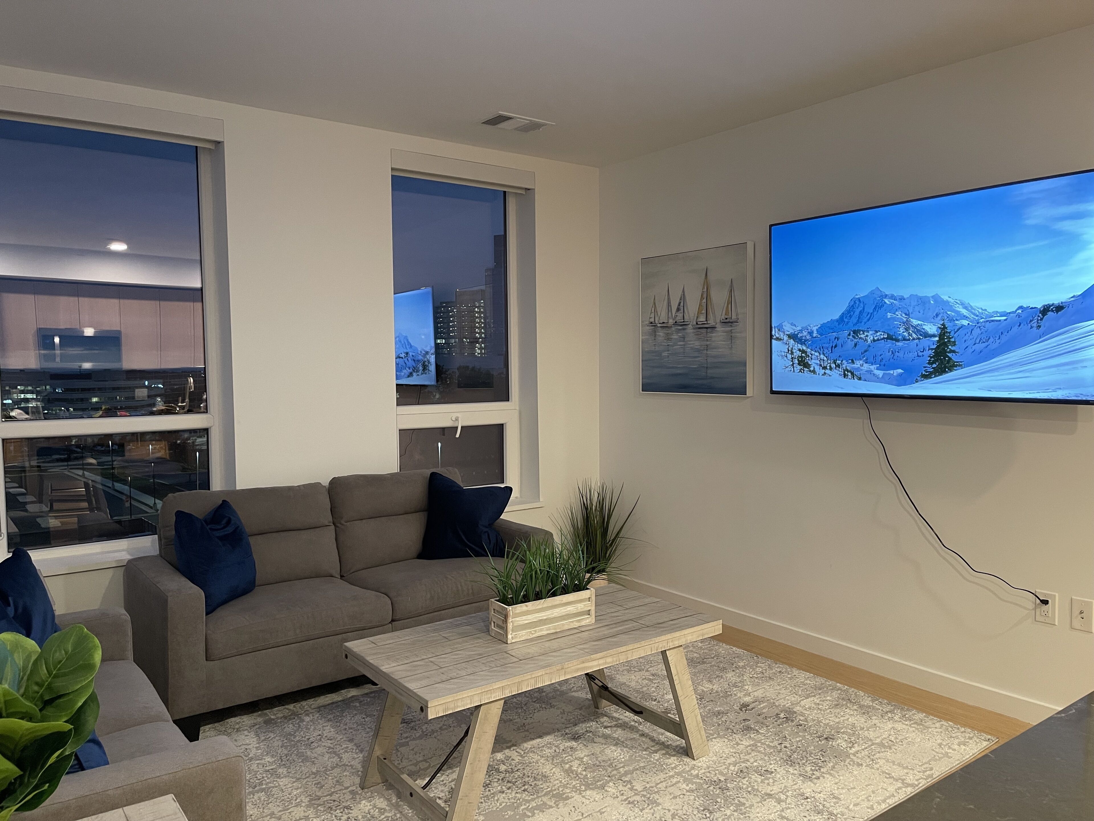 Una sala de estar moderna con un sofá, una mesa de centro y un televisor grande.