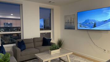 Una sala de estar moderna con un sofá, una mesa de centro y un televisor grande.